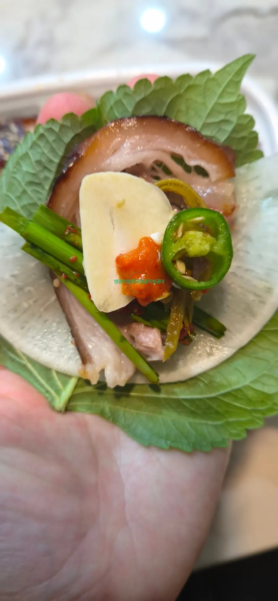 A wrap of Cheongmigwan jokbal with wrap greens