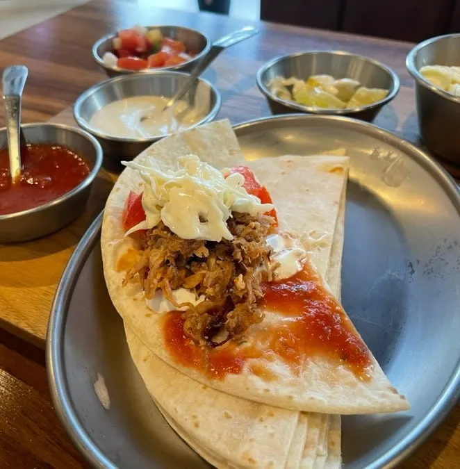 A taco assembled by hand with toppings