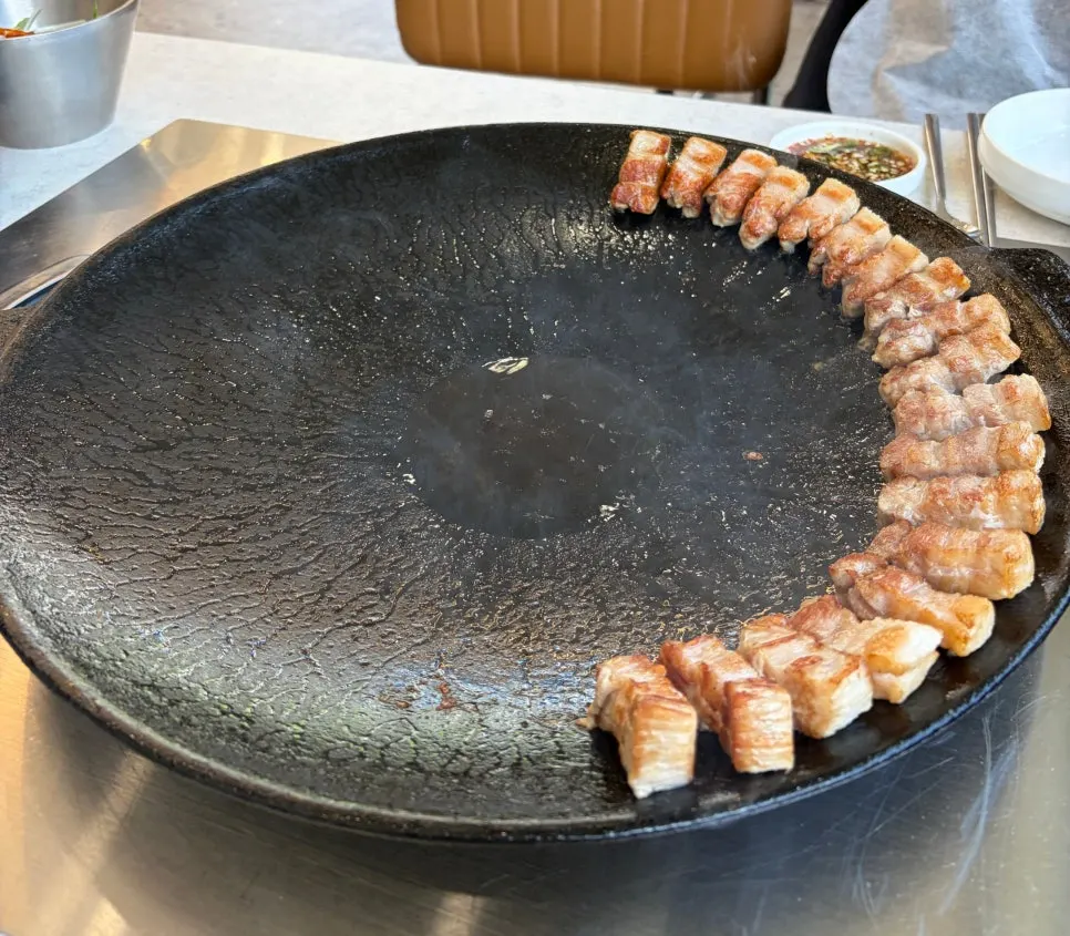 Kimchi whole pork belly served on a pot lid grill