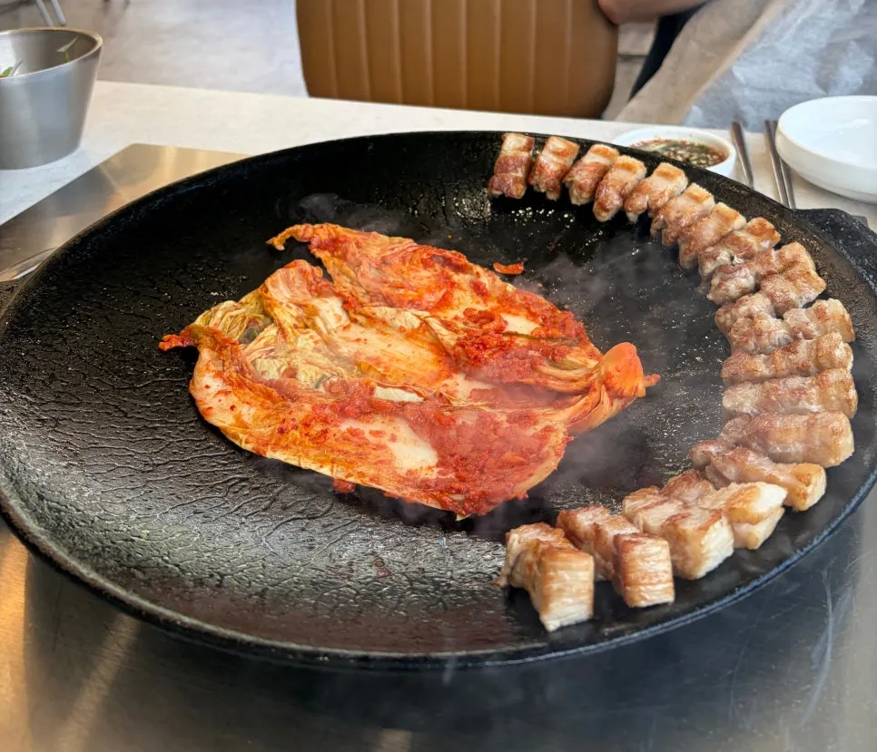 Whole pork belly and kimchi on a pot lid grill