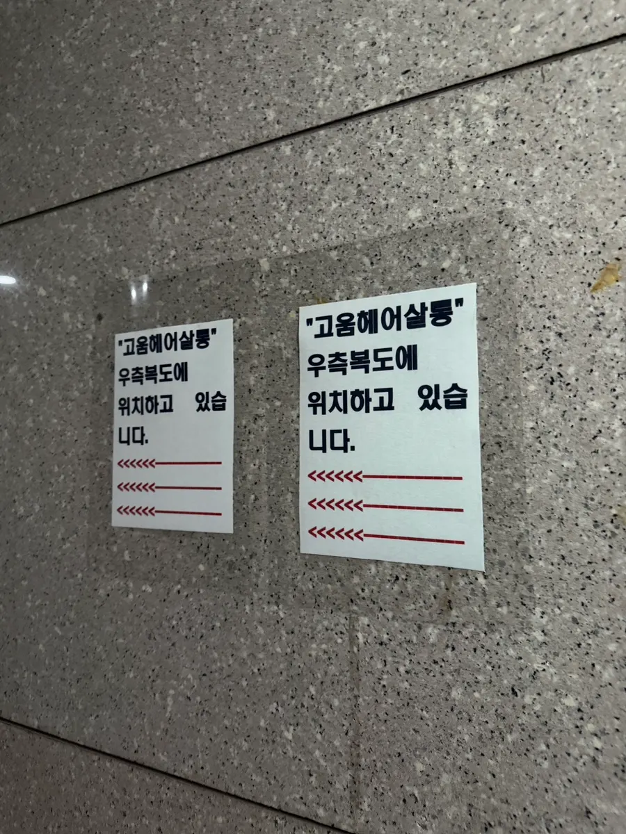 Salon location signage posted in the building corridor