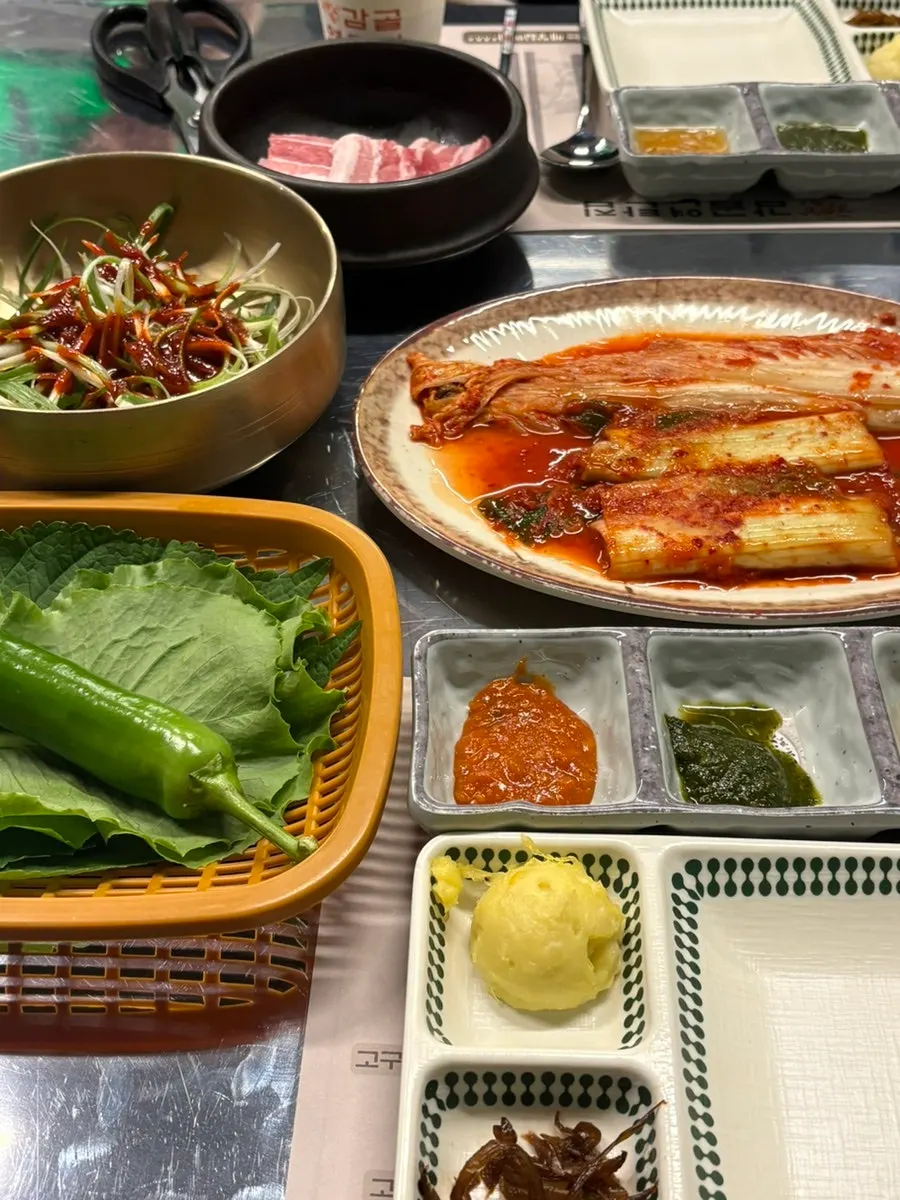 Table spread of green onion kimchi, scallion salad, and other basic side dishes