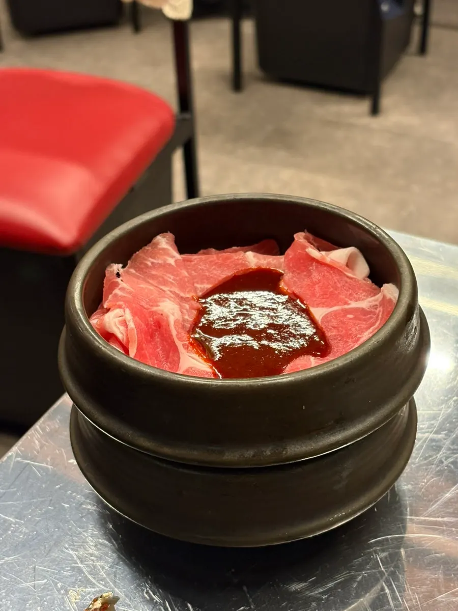 A glass of somaek enjoyed with pork belly