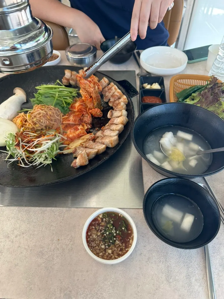 솥뚜껑에 차려진 김치 칼집통삼겹살 2인분 상차림