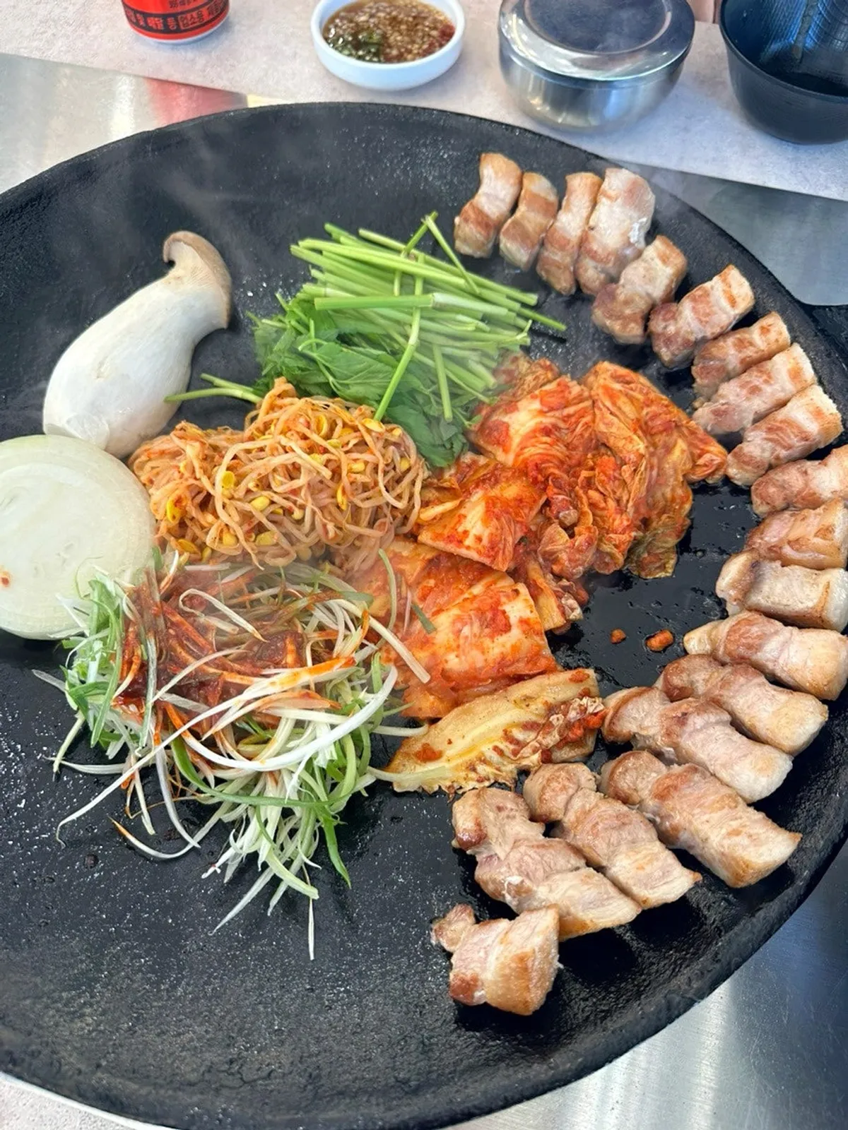 두툼한 칼집 통삼겹살이 구워진 솥뚜껑