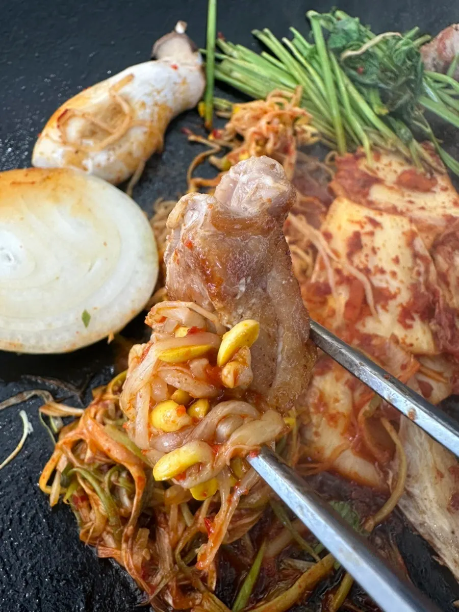 콩나물무침을 곁들인 삼겹살 한 점