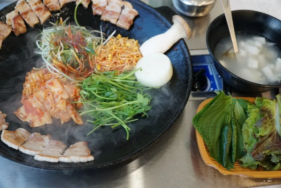 Dinner spread of kimchi pork belly, minari pancake and makgeolli