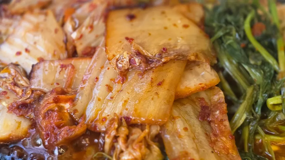 Pork belly topped with kimchi and minari