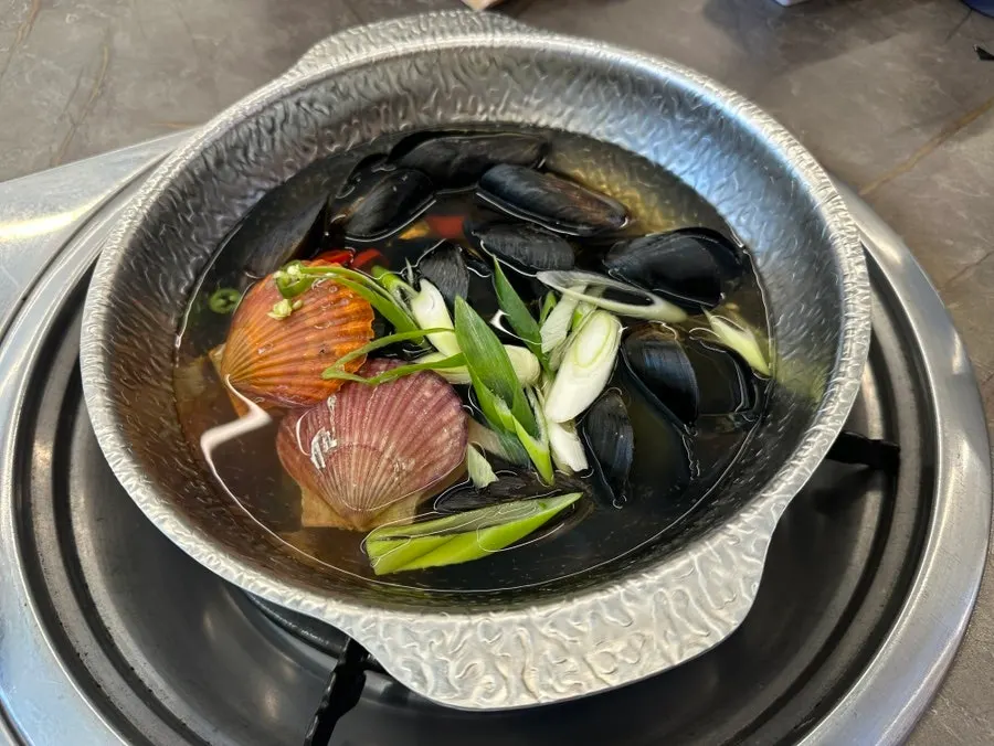 Table set with mini agu-jjim, mini clam soup, and fried monkfish