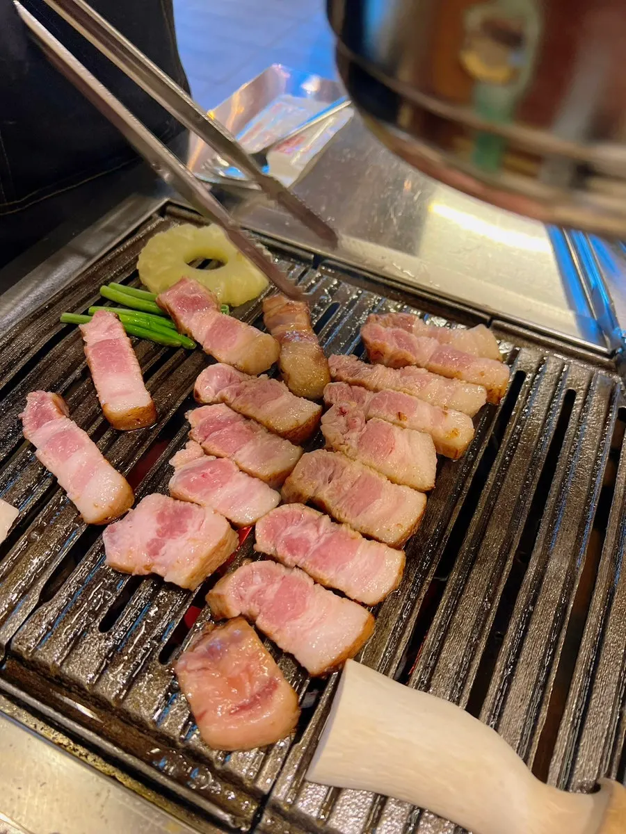 Staff grilling thick aged pork belly