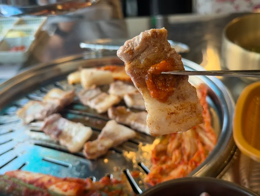 Grilled pork belly served with green onion salad and lettuce wrap