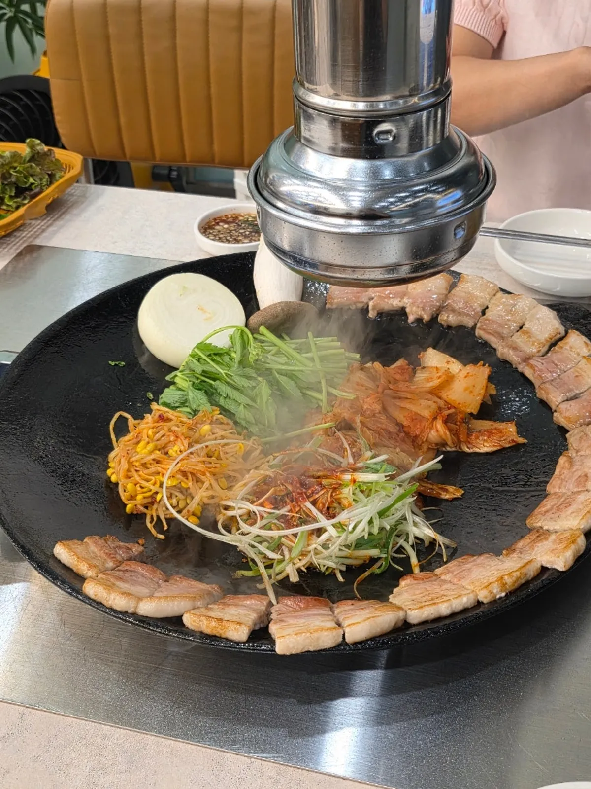 Pre-grilled kimchi pork belly served on a pot lid