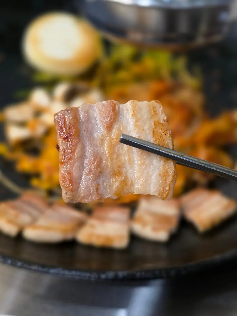 Pot-lid pork belly topped with minari and kimchi