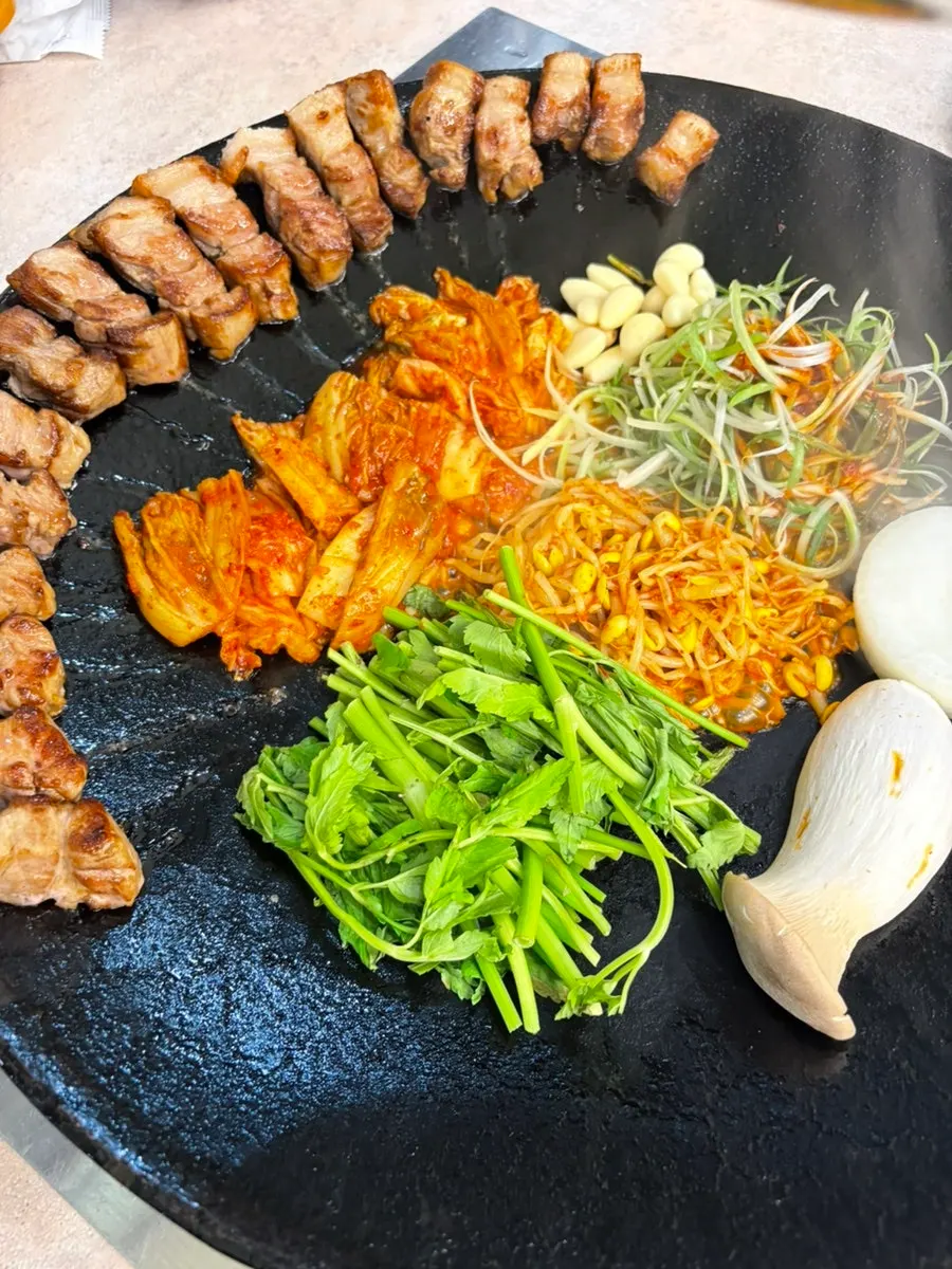 Kimchi pork belly grilled in a pot lid