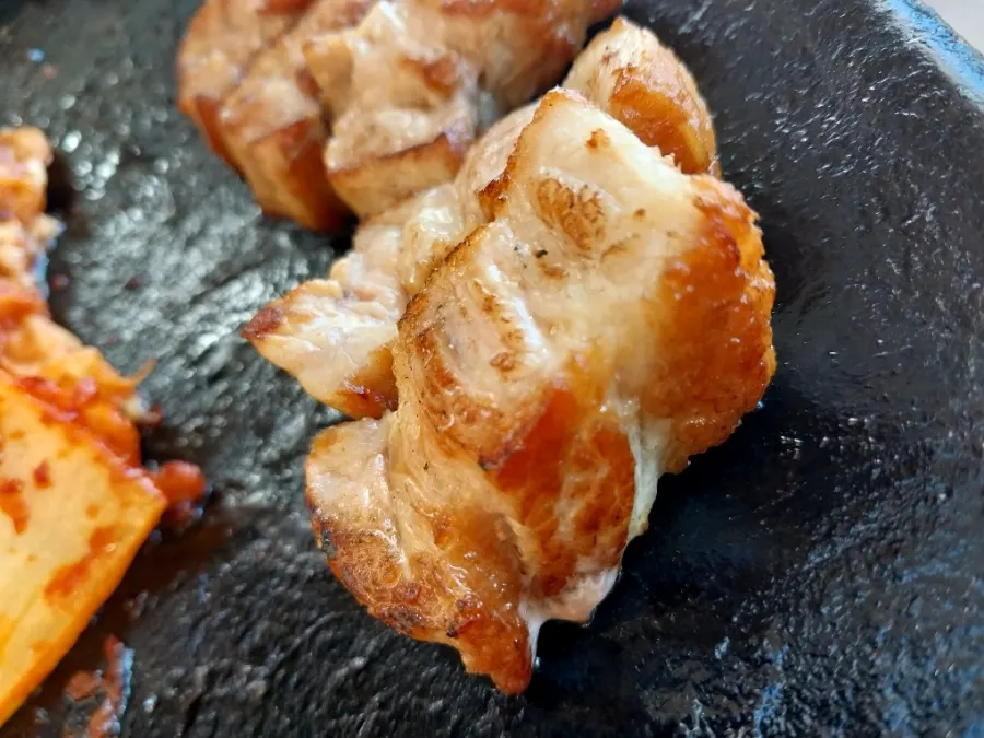 Pork belly and vegetables cooking on the pot lid