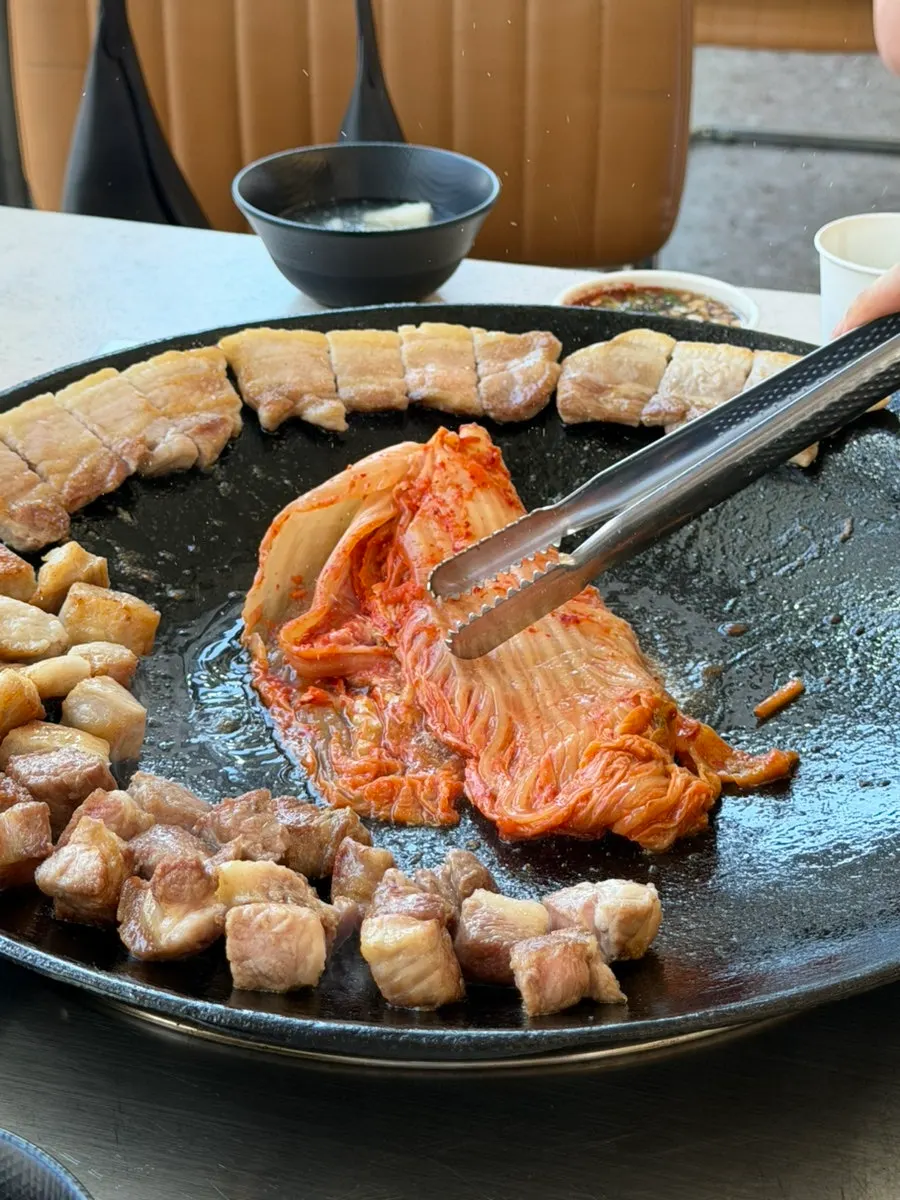 솥뚜껑 가장자리에 올린 초벌 삼겹살