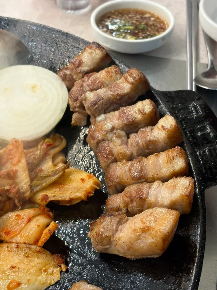 Thick-cut pork belly cooking on the hot pot lid