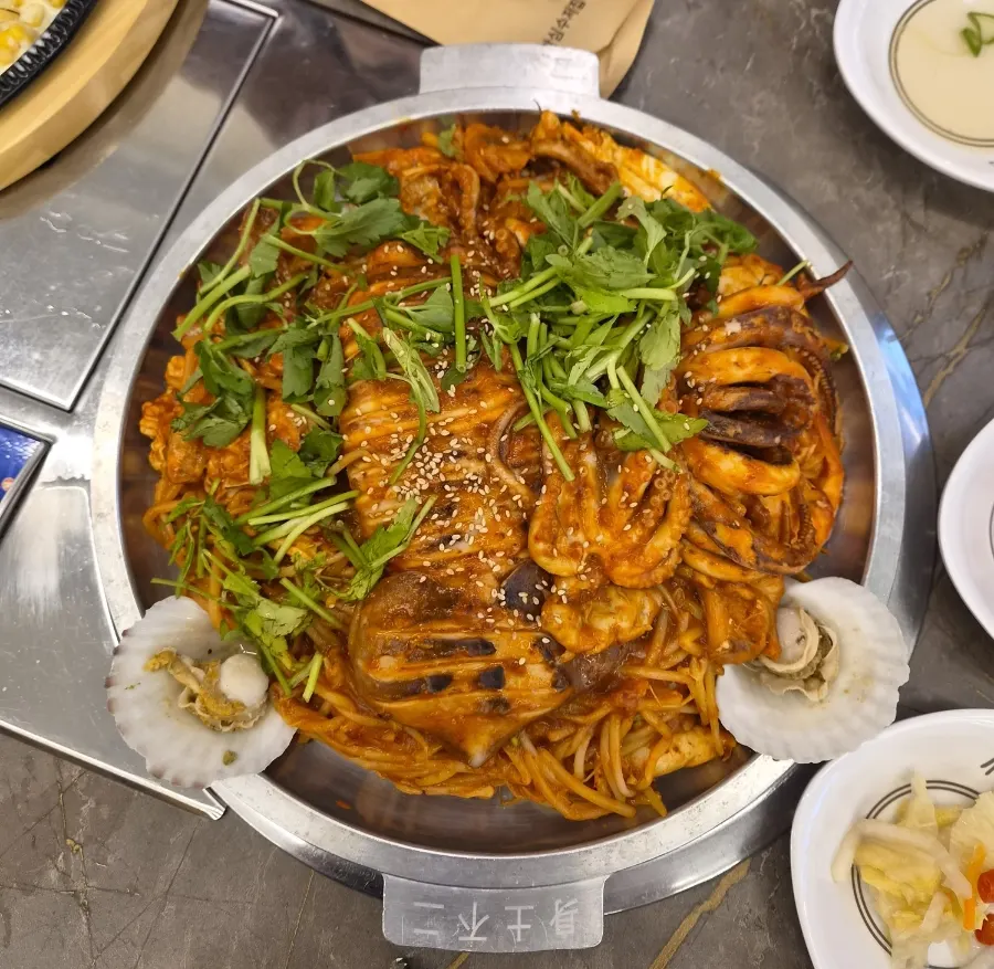 Small-size griddle seafood jjim topped with a whole squid