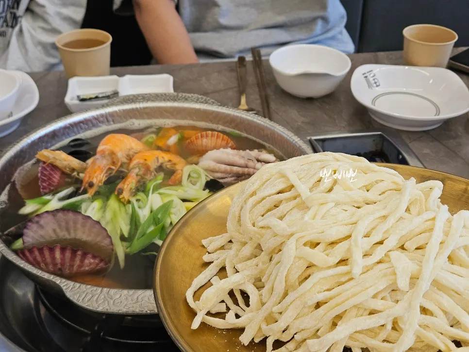 Pot of kalguksu loaded with seafood