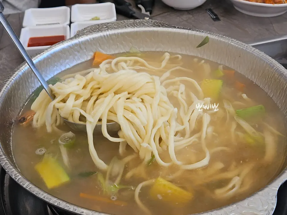 Hand-cut noodles cooking in the broth