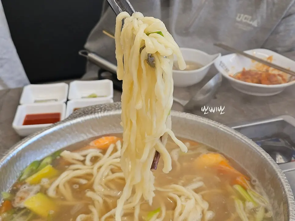 A well-stirred bowl of seafood hand-cut noodles