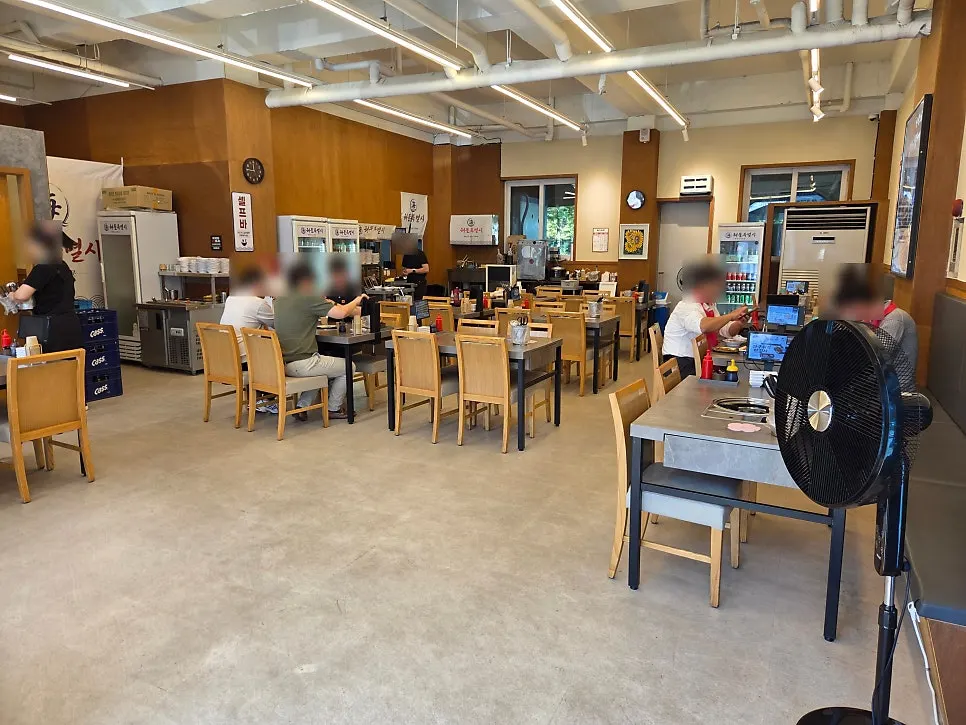 Spacious hall with wood-toned walls and 4-person tables