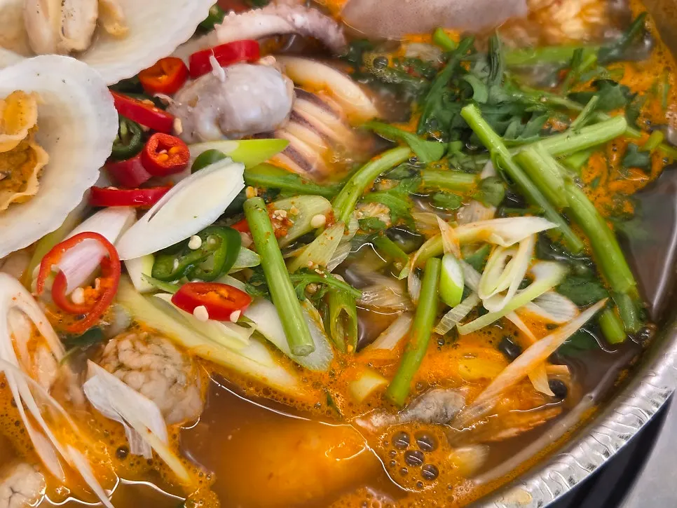 Seafood and scallions and chilies blended into the broth as it boils