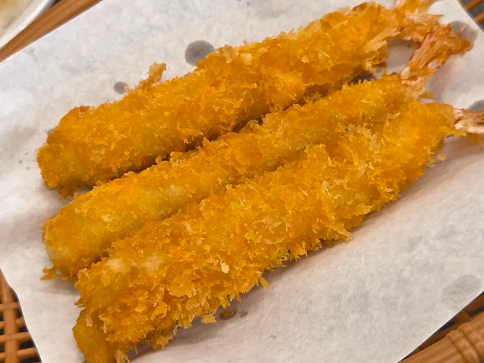 Large shrimp placed on top of a bowl of rice