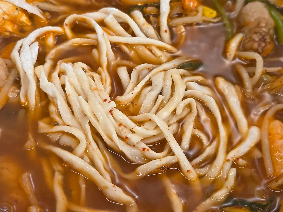 Fresh kalguksu noodles added into the seafood broth