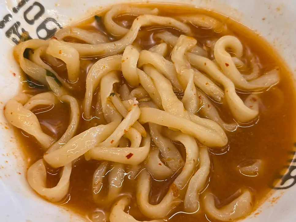Broth-stained noodles transferred into an individual bowl