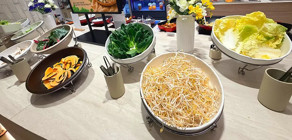 Salad bar with rice wrap vegetables and a sauce-pairing guide