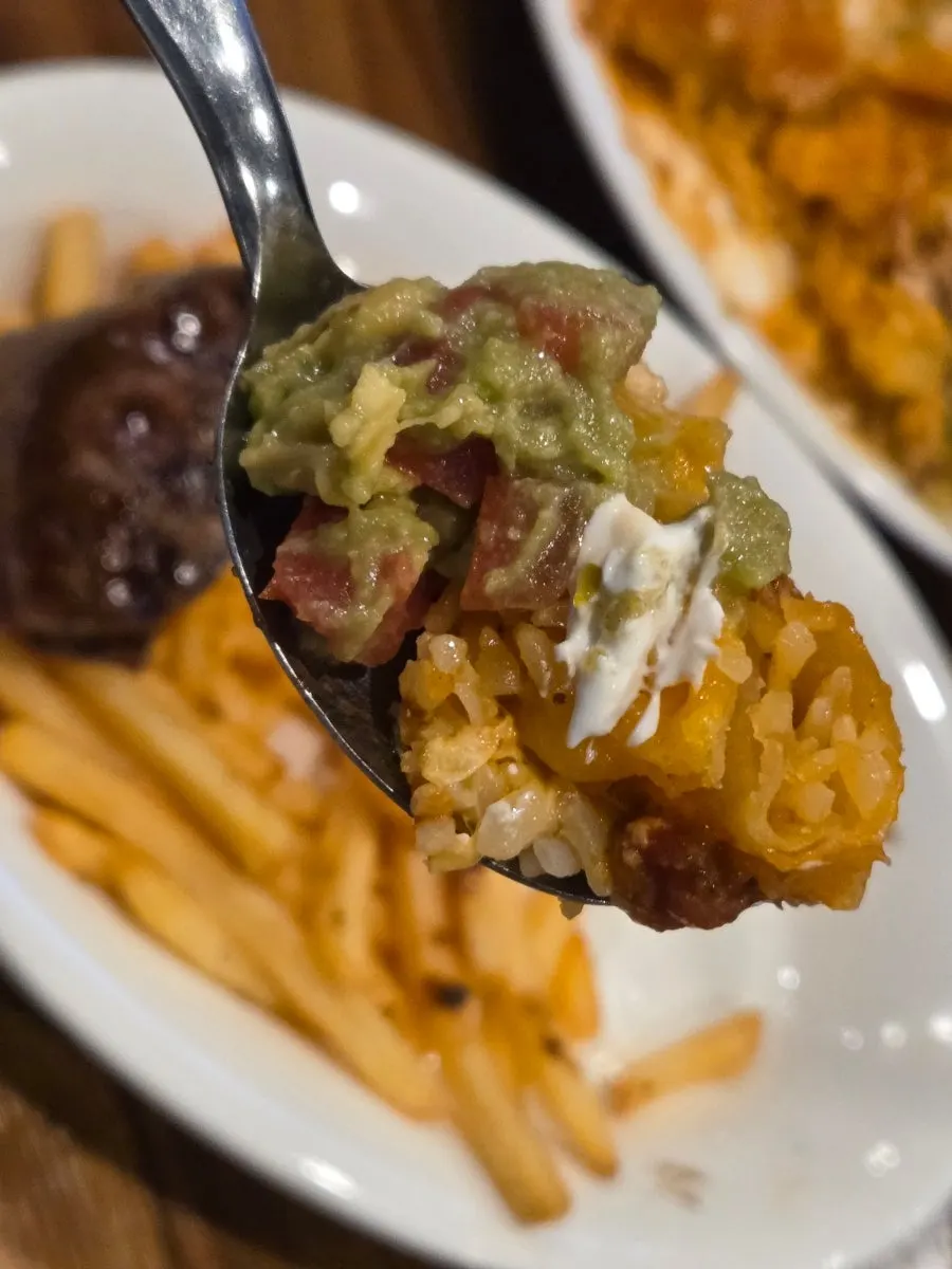 Eating chimichanga topped with guacamole