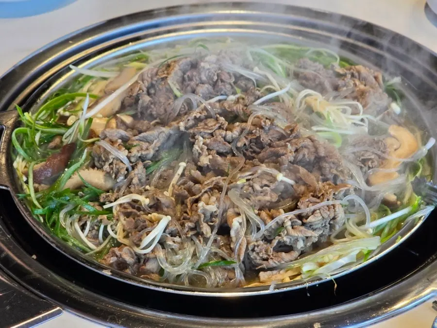 Cheongnyuok's beef bulgogi hot pot piled with green onion and glass noodles