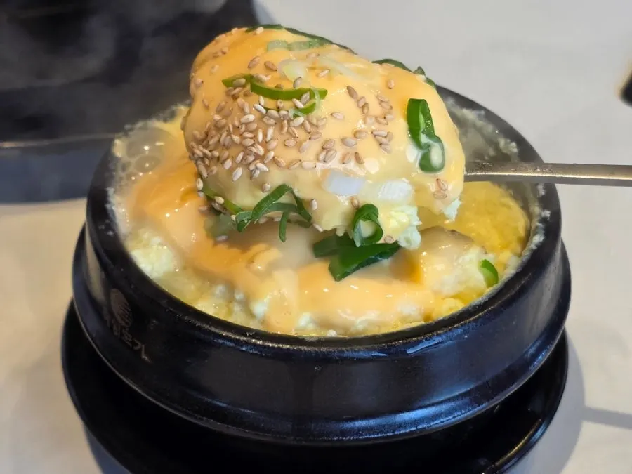 Cheese egg soufflé puffed up over the hot pot