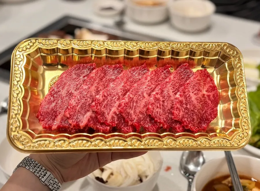 A piece of Korean beef dipped in pink salt