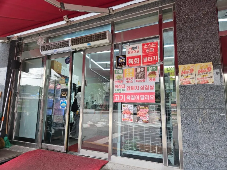 아리축산 문 앞에 붙은 네이버 예약 서비스 안내