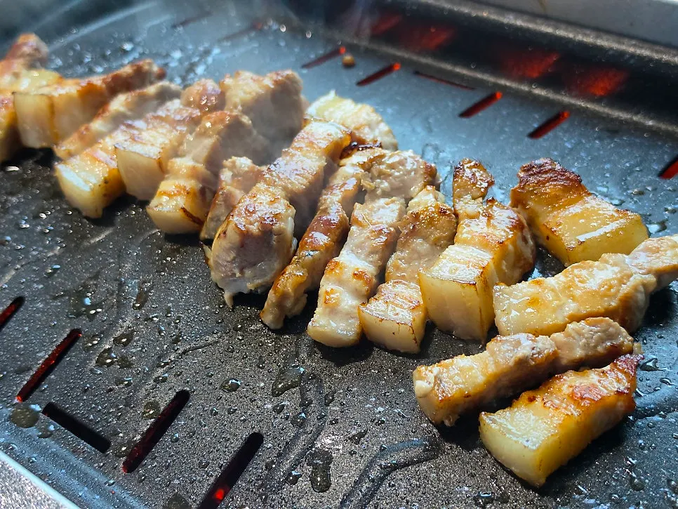 Thick pork belly cut with scissors while grilling