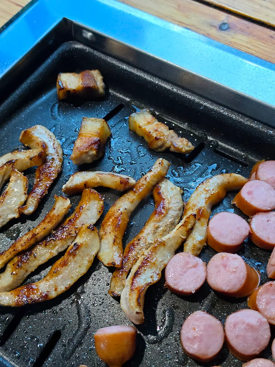 Pork jowl cooking on the grill