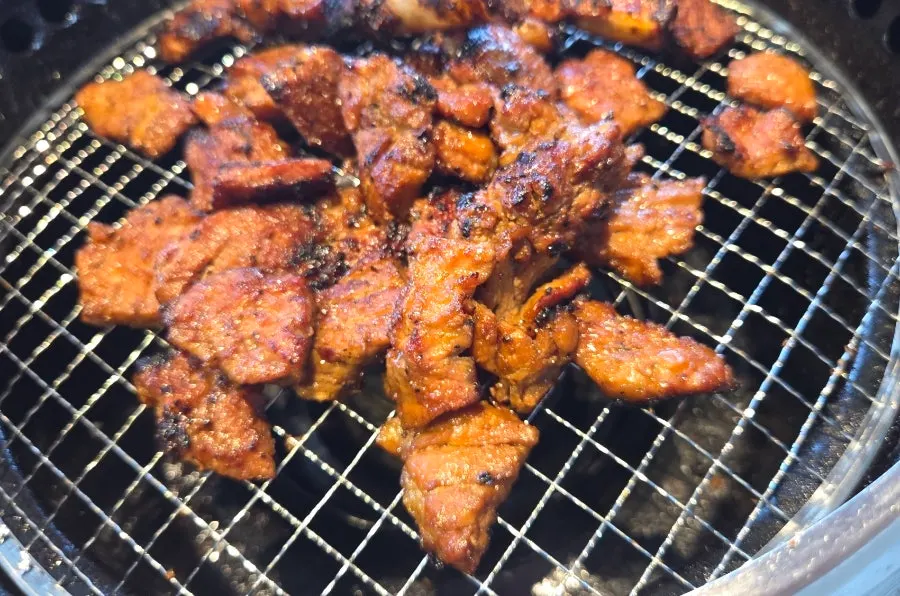 Marinated pork ribs grilling with charcoal aroma