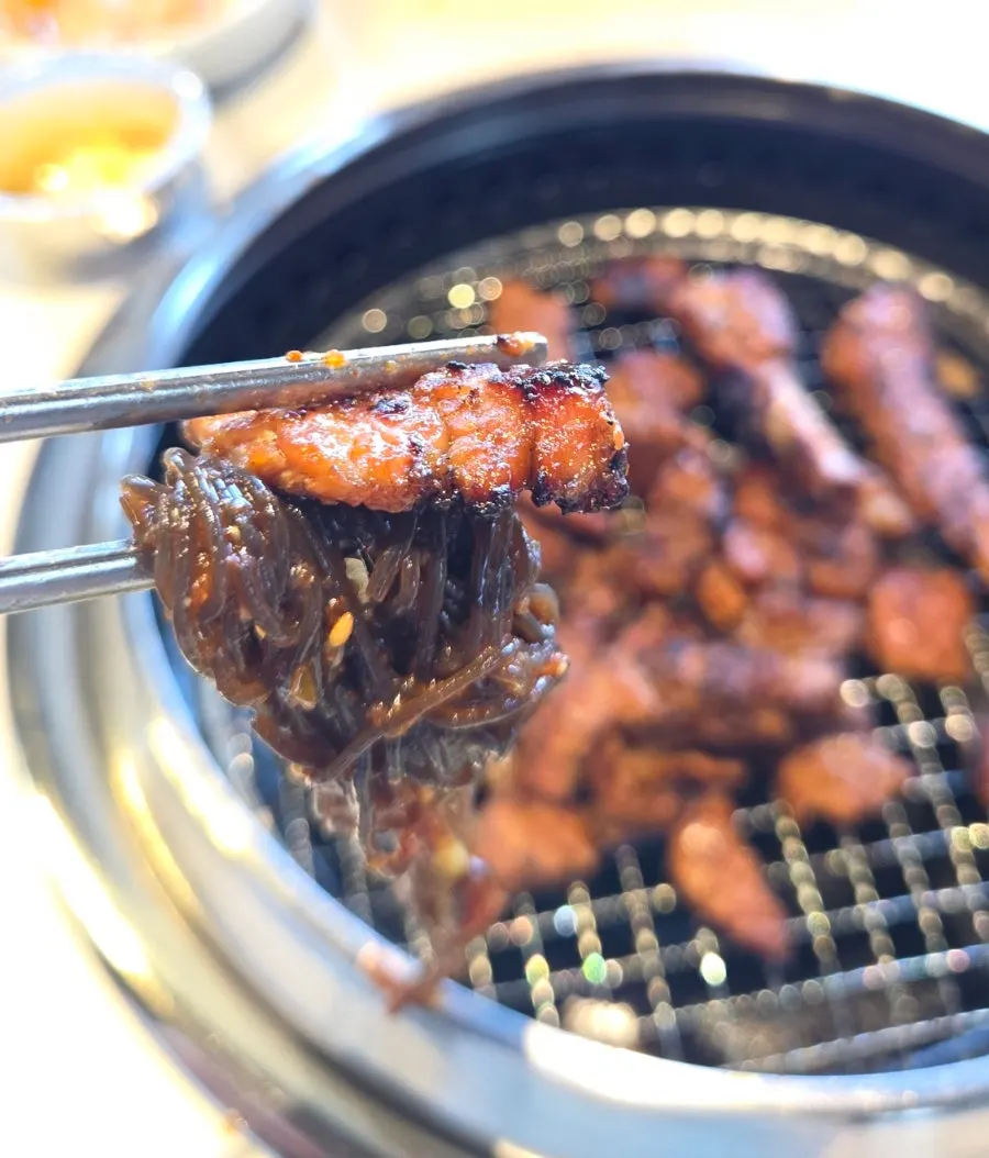 A bite of bibim naengmyeon topped with pork rib