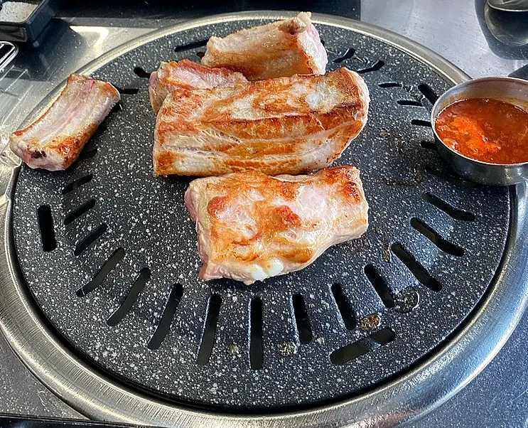 Staff member grilling pork rib on the grill plate
