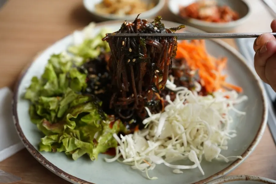 양념을 비벼 담은 쟁반막국수 한 젓가락