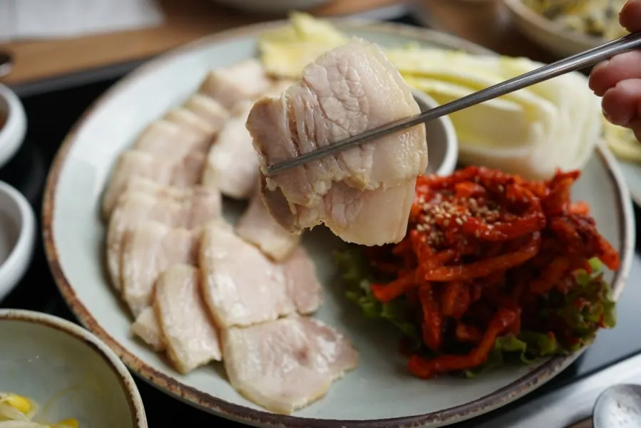 배추에 고기와 무김치를 올린 쌈