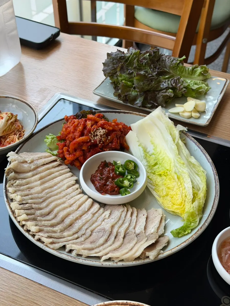 Bossam spread with bossam kimchi, chili peppers, ssamjang, and napa cabbage