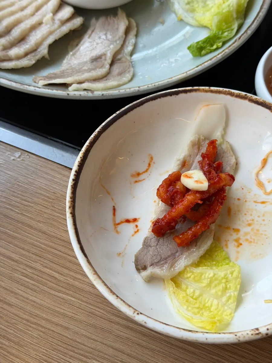 Gaburisal pork topped on bossam kimchi and napa cabbage wrap