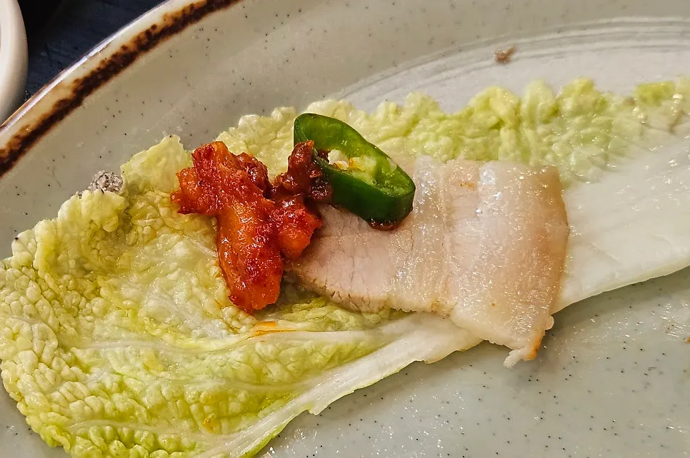 절임배추에 보쌈과 무김치를 올린 쌈
