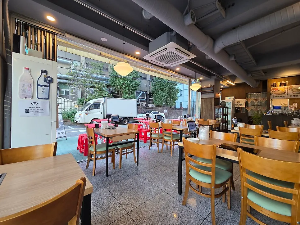 Street view of red patio tables in front of the restaurant