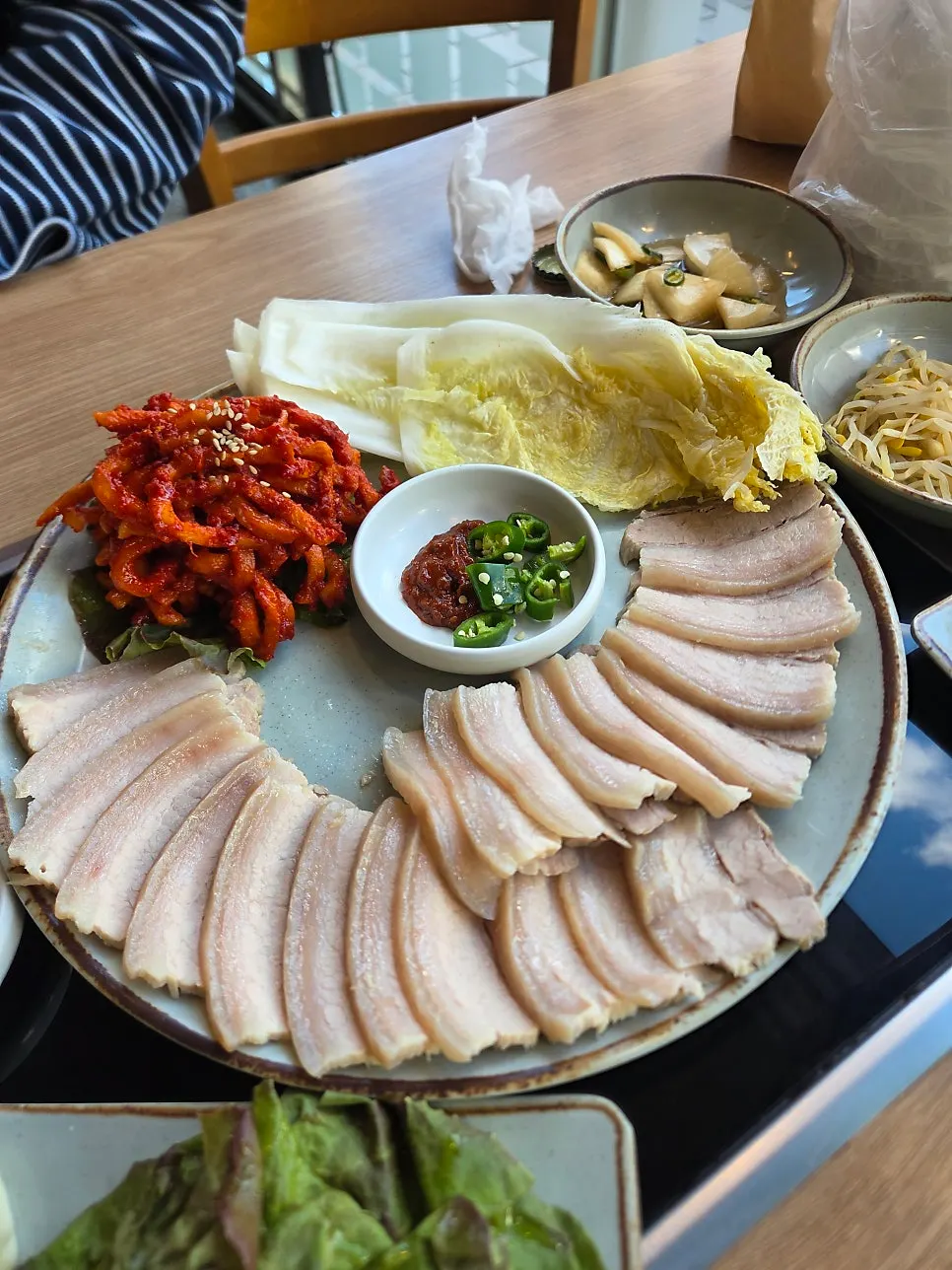Ohgyeop bossam served with dried radish salad and white kimchi