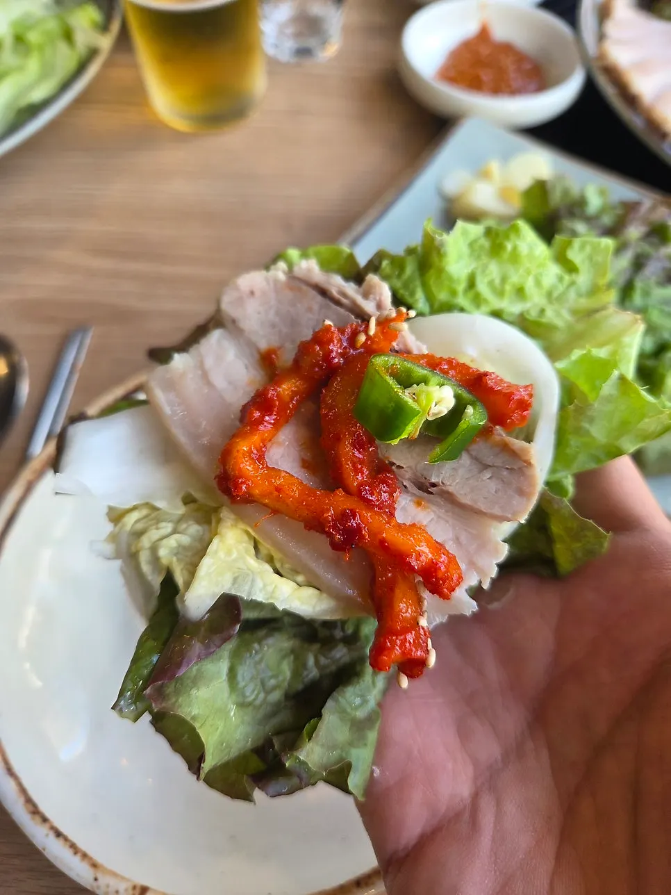 Lettuce wrap topped with white kimchi, meat, and dried radish