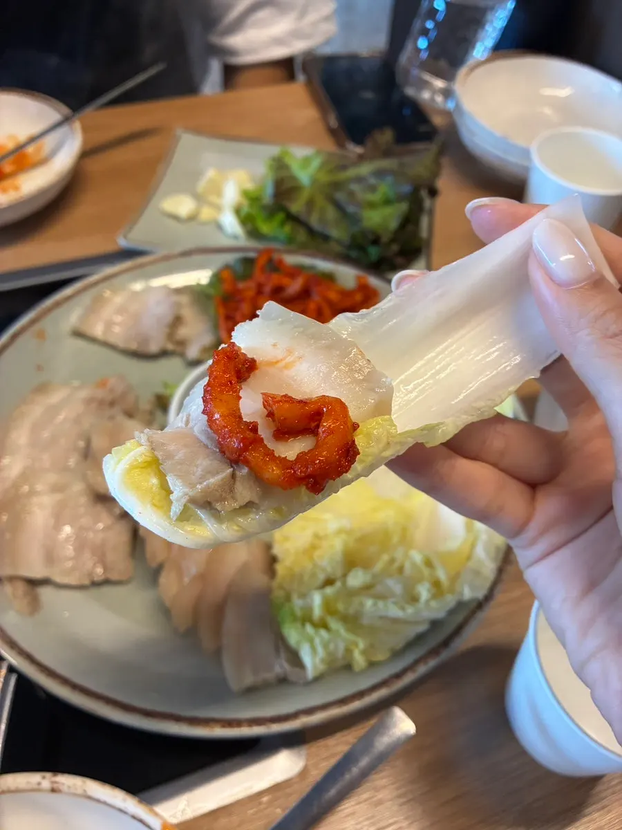 Bossam wrap with napa cabbage and dried radish strips